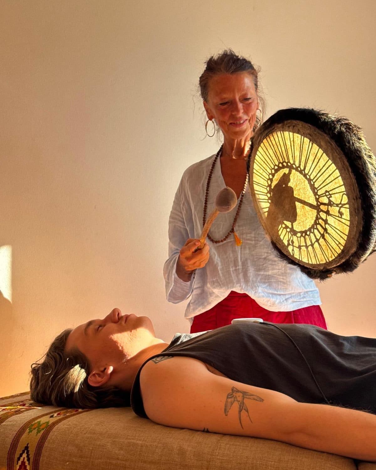 A frame drum played over a client resting on the treatment table
